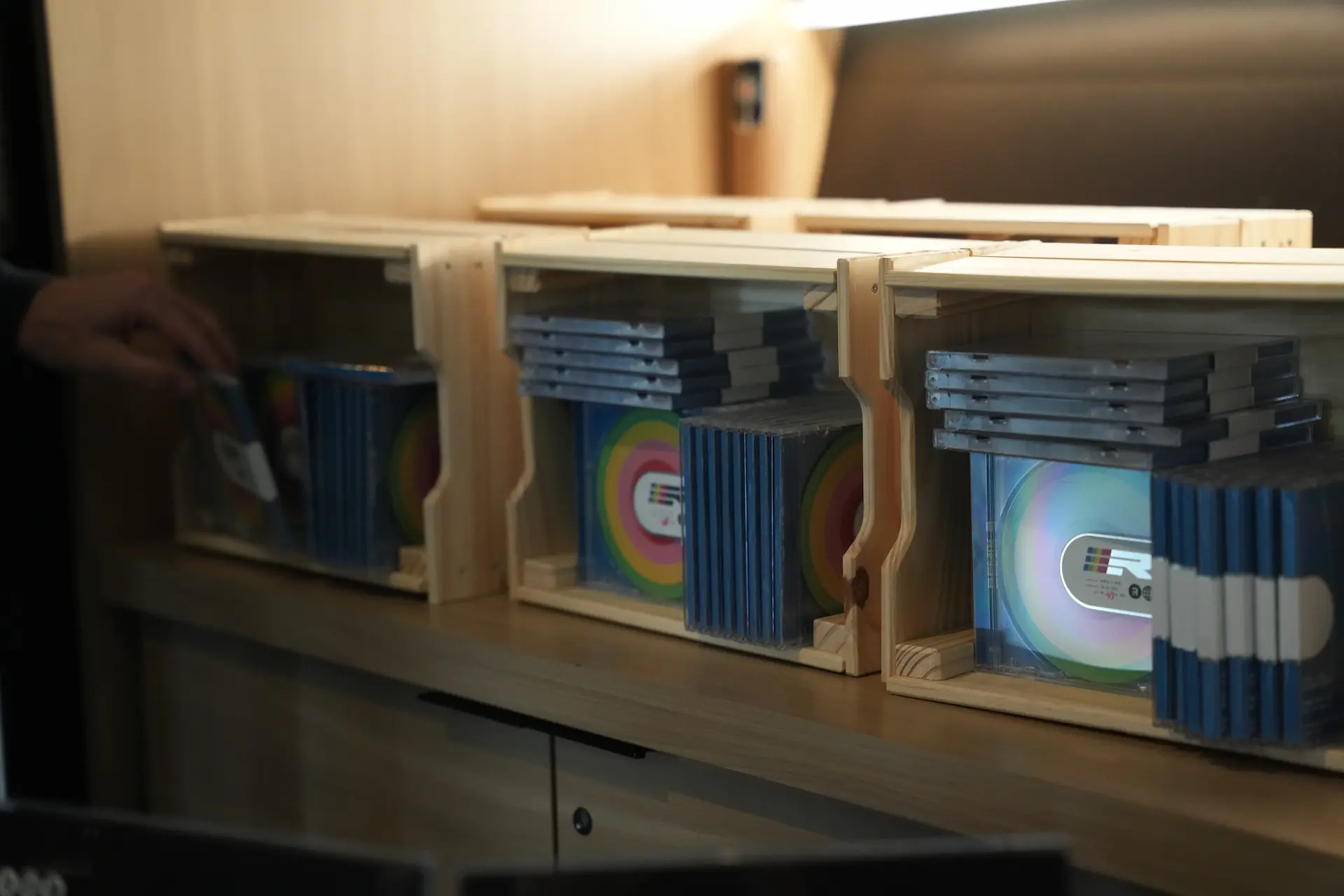 Remix Demo CDs in a display case with a hand reaching in to grab one